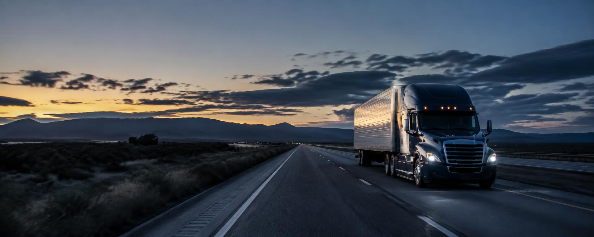 Semi truck traveling on an American interstate at dusk